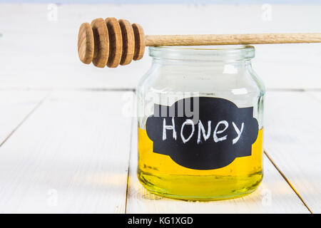 Mead jar miele marcato con un gocciolatore, su un tavolo bianco Foto Stock