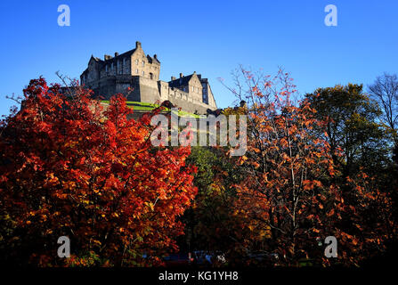 Il castello di Edimburgo è circondato dai colori autunnali degli alberi nei giardini di Princes street. Foto Stock