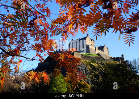 Il Castello di Edimburgo è circondato dai colori autunnali degli alberi dei Princes Street Gardens. Foto Stock