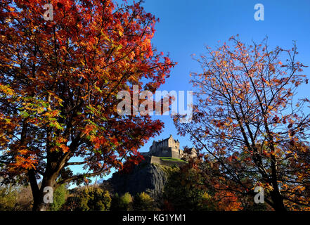 Il castello di Edimburgo è circondato dai colori autunnali degli alberi nei giardini di Princes street. Foto Stock