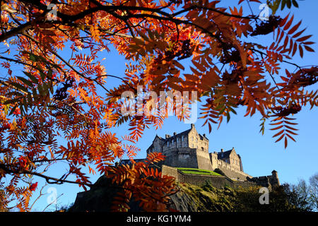 Il Castello di Edimburgo è circondato dai colori autunnali degli alberi dei Princes Street Gardens. Foto Stock