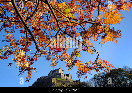 Il Castello di Edimburgo è circondato dai colori autunnali degli alberi dei Princes Street Gardens. Foto Stock