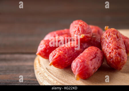 Piccole salsicce affumicate su un tavolo di legno Foto Stock
