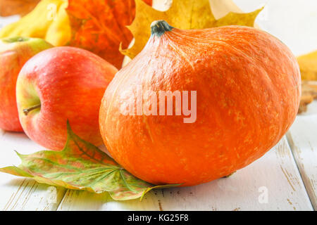 Zucca e Patty pan, mele e acero, rovere foglie gialle su una bianca tavolo in legno. raccolto autunnale. Foto Stock