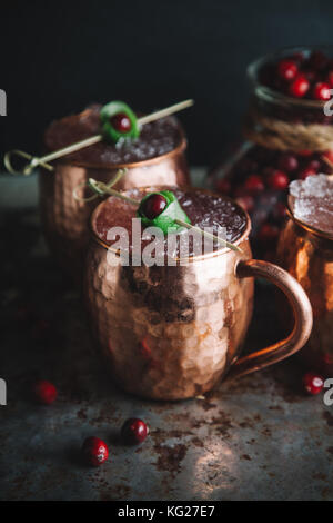 Mirtillo palustre e calce moscow mule cocktail scuro su sfondo moody Foto Stock