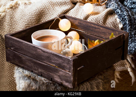 Casa deco interna con vassoio di legno con cioccolata calda tazza e lampadine decorazioni , accogliente coperta e pelliccia,accogliente winter particolari degli interni Foto Stock