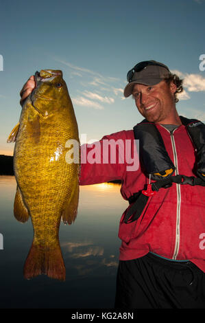 Uomo trofeo sollevamento smallmouth bass Foto Stock