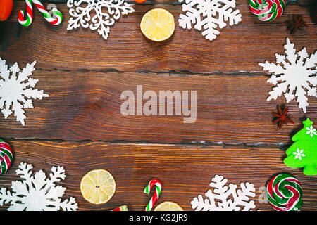 Sfondo di natale con i fiocchi di neve, coni, candy, secchi Arance e limoni, ornamenti e decorazioni. spazio libero Foto Stock