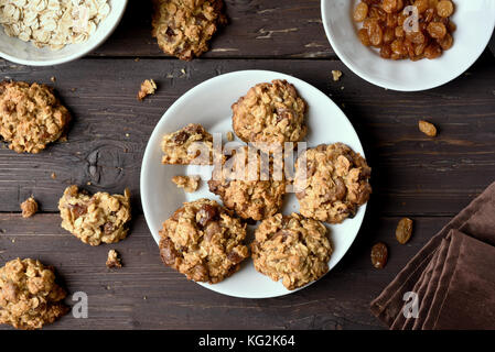 Gustosi fiocchi d'avena sana i cookie su piastra su sfondo di legno, vista dall'alto Foto Stock
