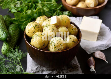Nuove patate bollite con aneto e il burro nel recipiente Foto Stock