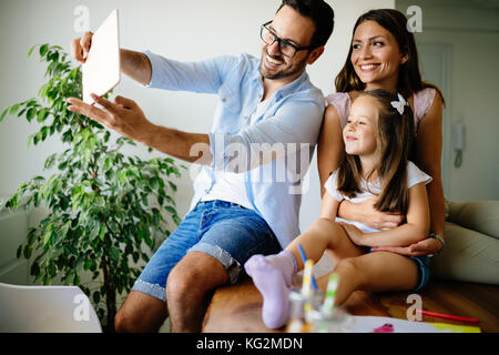 La famiglia felice tenendo selfie nella loro casa Foto Stock