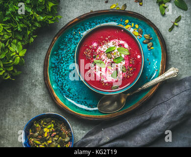 Molla di zuppa di barbabietole con foglie di menta e semi, vista dall'alto Foto Stock