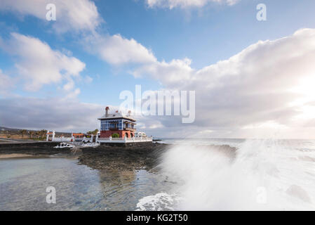 La mattina presto spruzzo su teh rocce accanto al prodotto "bambole casa' Juanita nel villaggio costiero di Arrieta, orientale Lanzarote, Canary Isalnds. Foto Stock