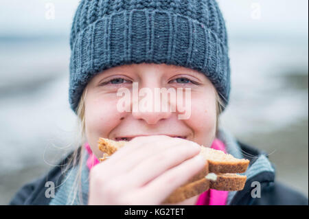 Giovedì 02 Novembre 2017 Un 11,12,13, anno vecchia ragazza mangia un sano panino al di fuori Foto Stock