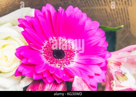 Un mazzo di fiori da un giglio, gerbera, rose bianche e alstroemeria su un bianco tavolo in legno. Una vacanza, un dono. Foto Stock