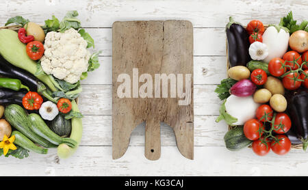 Mangiare sano concetto tagliere di legno con cesto pieno di verdure su cucina piano bianco, copia spazio, vista dall'alto Foto Stock