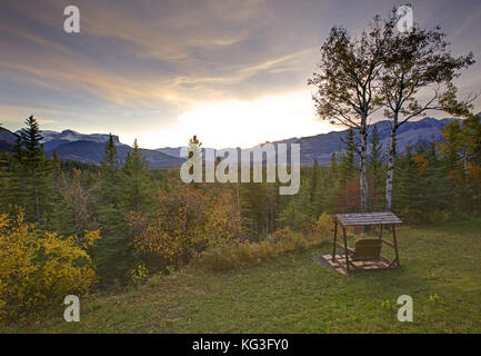 Un bellissimo tramonto su altalene in legno con montagne rocciose canadesi in dietro Foto Stock