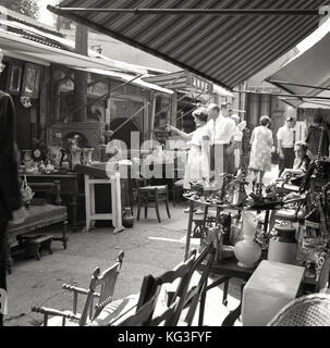 Degli anni Cinquanta, foto storiche, persone navigando in una fase di stallo in uno di Parigi il famoso 'marche aux puces', mercati delle pulci, dove l'antiquariato, mobili, dipinti, ninnoli e tutto il resto è in vendita. Foto Stock