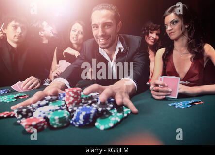 Giocatore di poker andando "tutti in' spingendo le sue chips in avanti Foto Stock