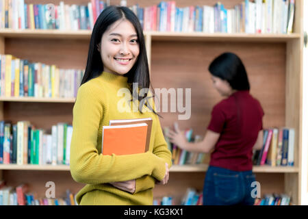 Un gruppo di studenti asiatici che studiano insieme in biblioteca presso università. Gli studenti universitari. Foto Stock