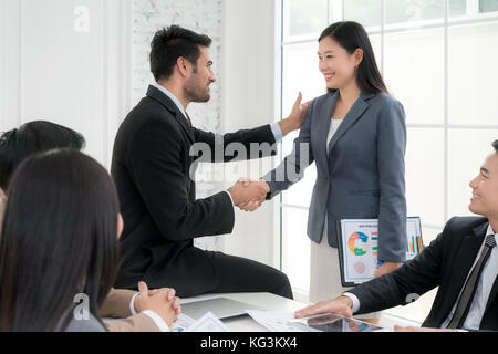 Asian imprenditore e imprenditrice stringono le mani in sala conferenze. La gente di affari stringono le mani il concetto di accordo. Foto Stock