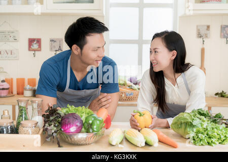 Giovani asiatici giovane preparare il cibo insieme al contatore in cucina. felice amore giovane concetto. Foto Stock