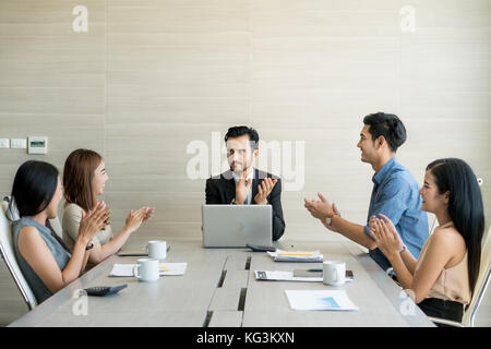 Mani di business partner per applaudire al reporter dopo aver ascoltato la presentazione alla riunione. Foto Stock