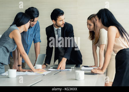 Gruppo di multi-etnico business partner per discutere le idee in una sala riunioni presso l'ufficio. la gente di affari sale riunioni per la comunicazione aziendale concetto di lavoro di squadra. Foto Stock
