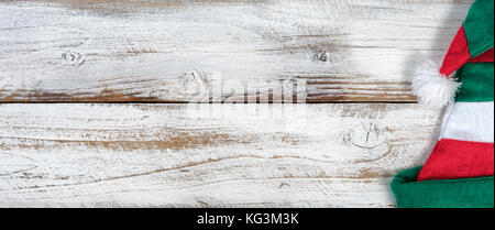 Tradizionale natale elf hat decorazione su rustico in legno nodoso nel piatto formato laici Foto Stock