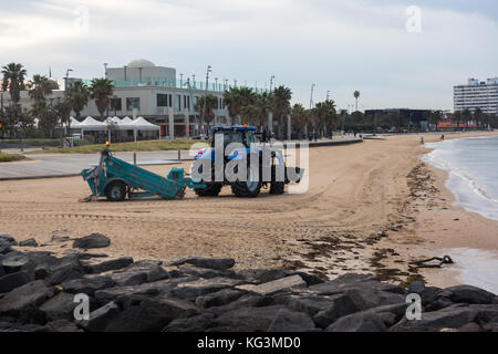 Un trattore pettinatura della sabbia per i rifiuti presso la spiaggia di St Kilda, Victoria. Australia. Foto Stock