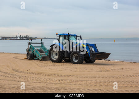 Un trattore pettinatura della sabbia per i rifiuti presso la spiaggia di St Kilda, Victoria. Australia. Foto Stock