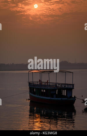 Una barca è galleggiante sul fiume Gange al momento del sorgere del sole in varanasi,l'india. Foto Stock