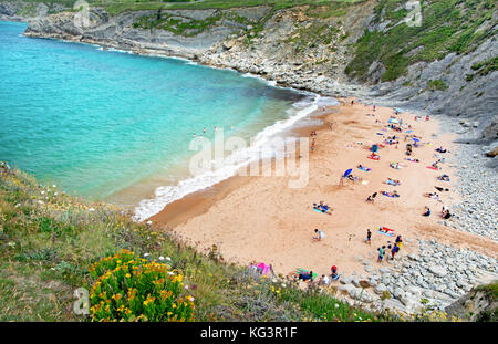 Playa de San Julian, Spagna - luglio 6, 2016: persone sconosciute sulla spiaggia. La vista dall'alto sulla piccola spiaggia di sabbia tra rocce. estate, Cantabria, northe Foto Stock