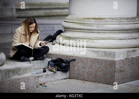 Studente artista delineando nel centro della città di Manchester. Foto Stock