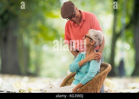 Coppia senior per godersi la natura in esterno seduto sulla sedia di vimini Foto Stock