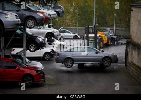 Auto Motorhog cantiere di scarto a Huddersfield, vetture demolite su scaffalatura righe. Foto Stock