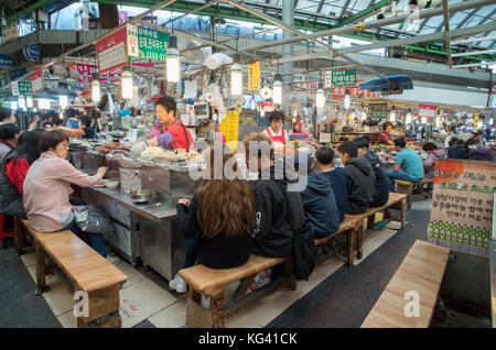 Foodstall nel mercato Gwangjang a Seul, Corea del Sud che serve tradizionali gnocchi di patate, kimchi e altri autentica Cucina Coreana Foto Stock