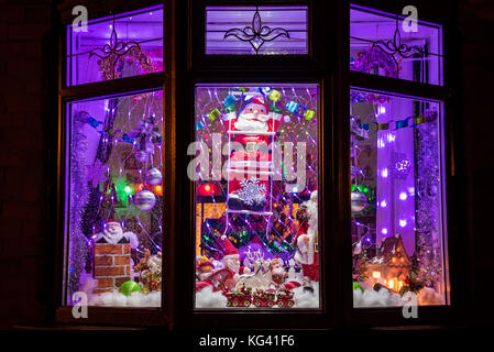 Una stravagante visualizzazione delle decorazioni di Natale in un interno nella finestra anteriore. Foto Stock