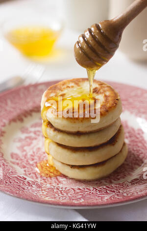 Cottage cheese pancakes, syrniki fatti in casa con il miele e panna acida. Foto Stock