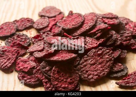 Viola barbabietola cotta chips closeup su sfondo di legno Foto Stock