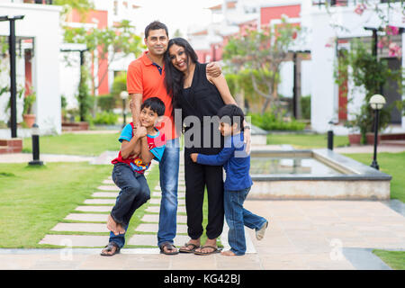 La famiglia felice in piedi al di fuori della loro casa e quartiere. Foto Stock