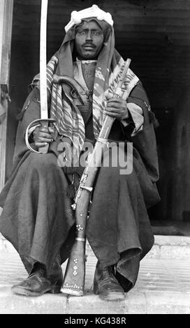 Archivio immagini in bianco e nero di un soldato beduino armati con un fucile, spada e pistola circa 1920 Foto Stock