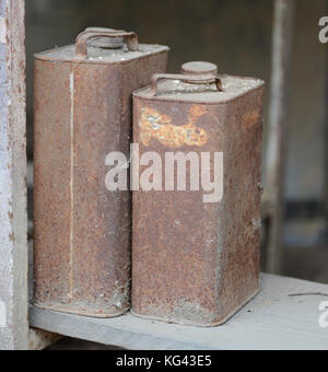 Due vecchio metallo arrugginito lattine di olio Foto Stock