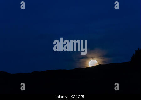 Ballydehob, West Cork, Irlanda. Sabato 4 Novembre, 2017. La luna piena o "Beaver Moon", così chiamato perché è l'ultima luna piena prima di inverno, autore di una spettacolare via attraverso il cielo durante la notte ed è raffigurato l'impostazione sul Monte Corrin, Ballydehob. Questo anno il Beaver Luna ha appena perso il treno che viene dichiarata una super luna, ma è ancora il 14 percento più grande e quasi un terzo più luminoso rispetto al solito. Il Beaver Moon è atteso a comparire di nuovo stasera in Irlanda e nel Regno Unito. Credito: Andy Gibson/Alamy Live News. Foto Stock