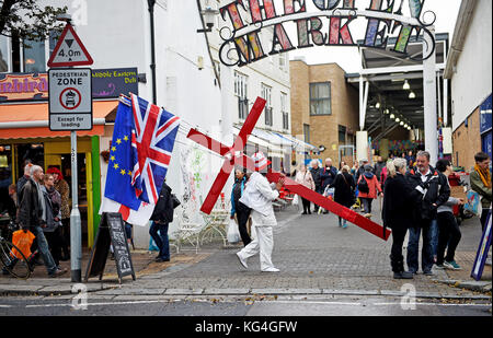 Brighton, Regno Unito. 4 novembre 2017. Un uomo con una grande croce rossa e varie bandiere, tra cui le Europe Stars, cammina attraverso il centro di Brighton in un triste ma caldo pomeriggio autunnale, ma si prevede che le temperature crollino nei prossimi giorni in tutta la Gran Bretagna Fotografia scattata da Simon Dack/Alamy Live News Foto Stock