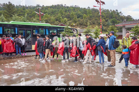 Lijiang, Yunnan, Cina - 23 Settembre 2017: turisti attendere in linea per un autobus in Blue Moon Valley scenic area in un giorno di pioggia. Foto Stock