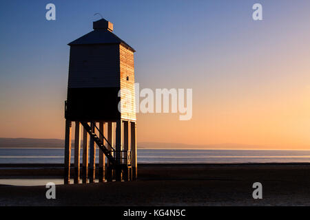 Burnham on sea, legno, faro illuminata da un sole di setting su una chiara serata d'estate. Foto Stock