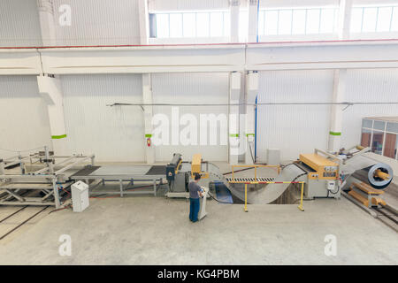 Macchina per il taglio di lamiere in acciaio in rotoli. lavorazione della lamiera in rotoli Foto Stock