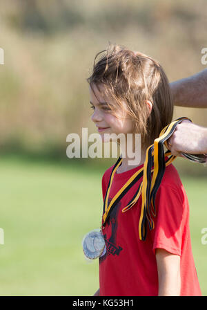 A fine stagione del premio per un 6yr. old girl giocando in una partita di calcio. Waterbury, Vermont, USA Foto Stock