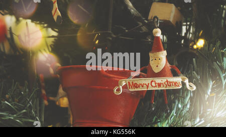 Saluto il concetto di stagione.close up di ornamenti su un albero di Natale con luci decorative Foto Stock